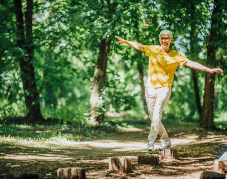A woman doing balancing exercises outdoors.