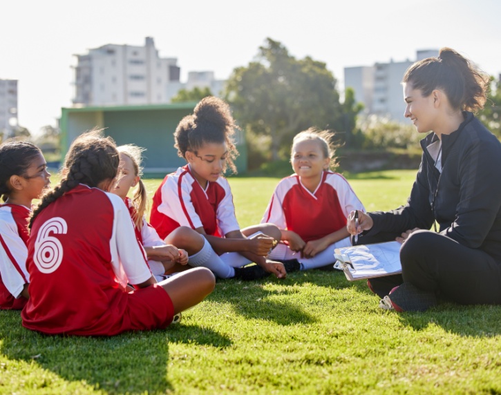 A woman coaching a girl’s football team.
