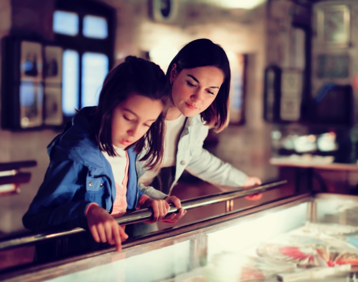 A mother and daughter viewing a museum exhibit.